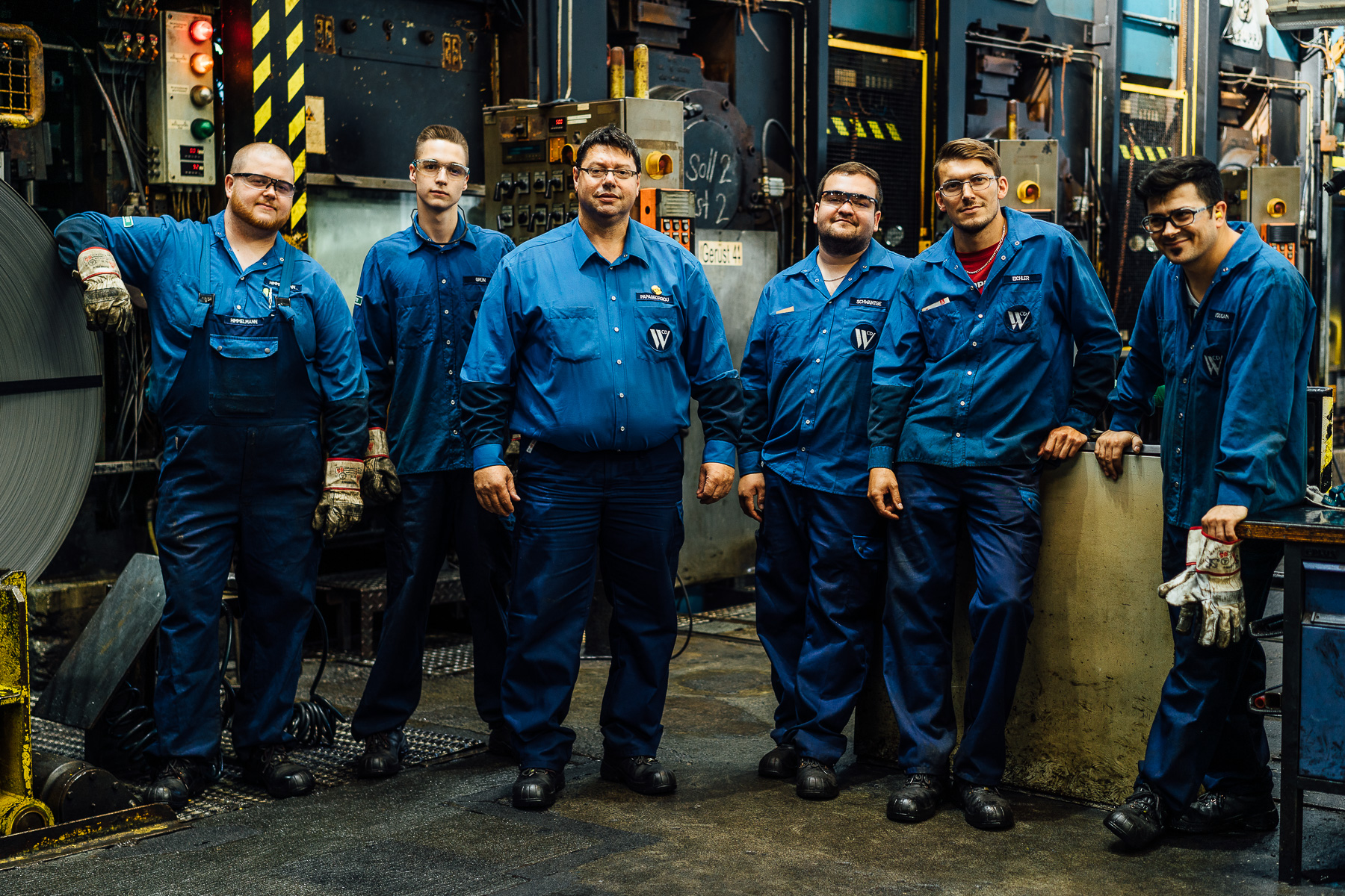 CDW Waelzholz - Gruppenbild von 6 Mitarbeitern vor einer Walze für Bandstahl