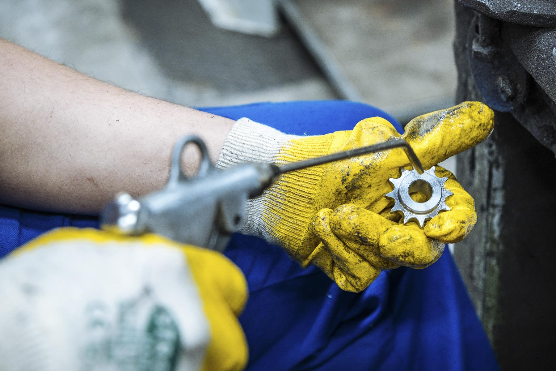 Eine Hand hält ein Kettenrad und reinigt es