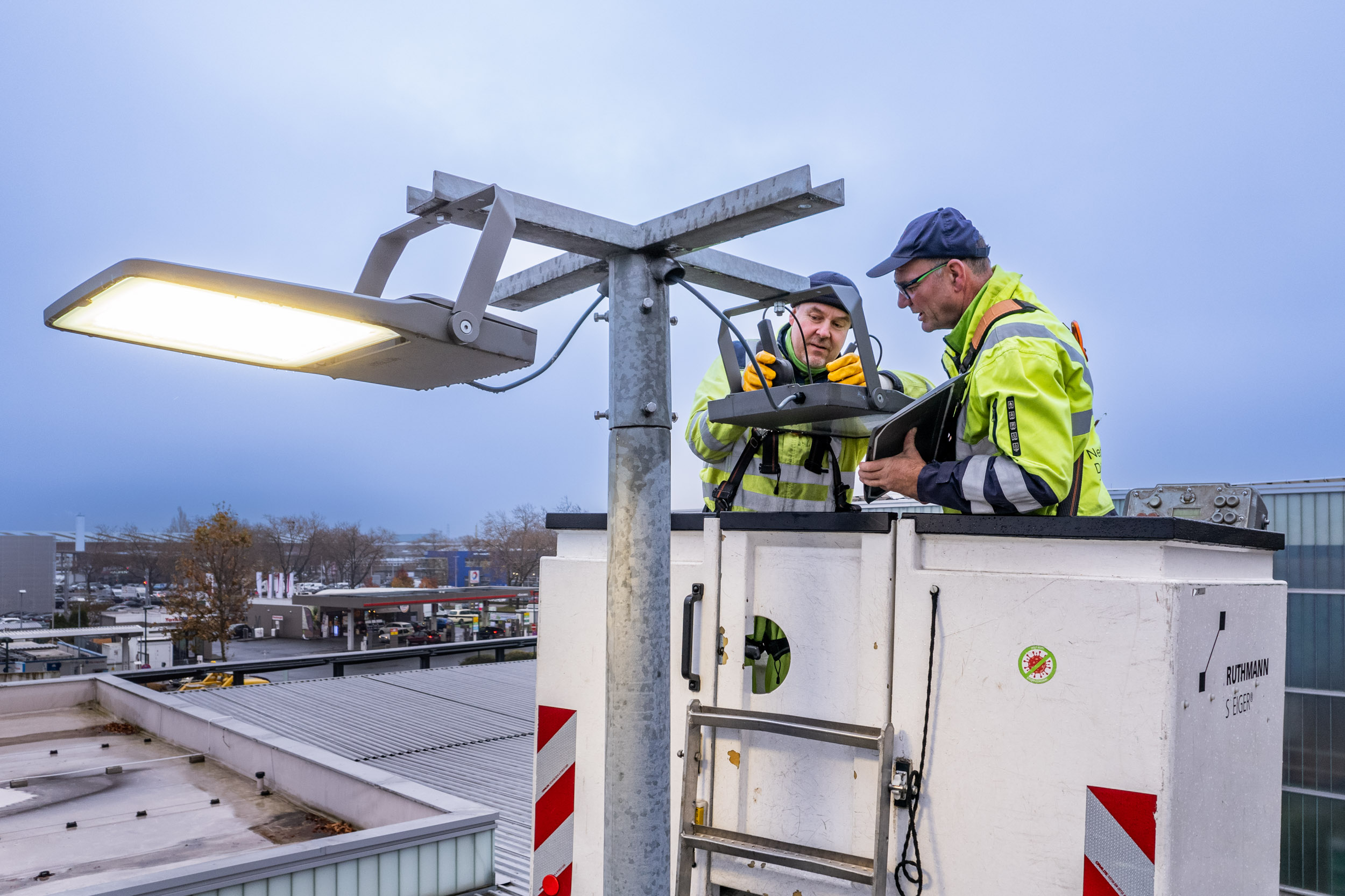 2 Mitarbeiter auf einem Steiger bei der Montage an einer Straßenlaterne